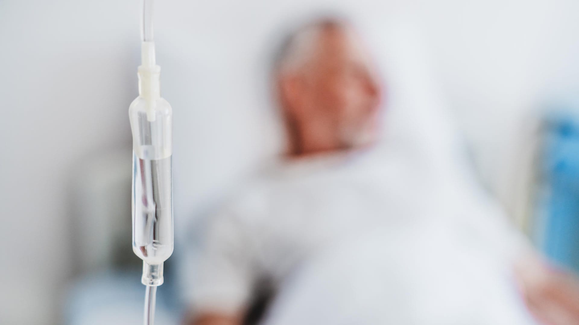 Infusion, im Hintergrund ein älterer Patient Infusion, im Hintergrund ein älterer Patient