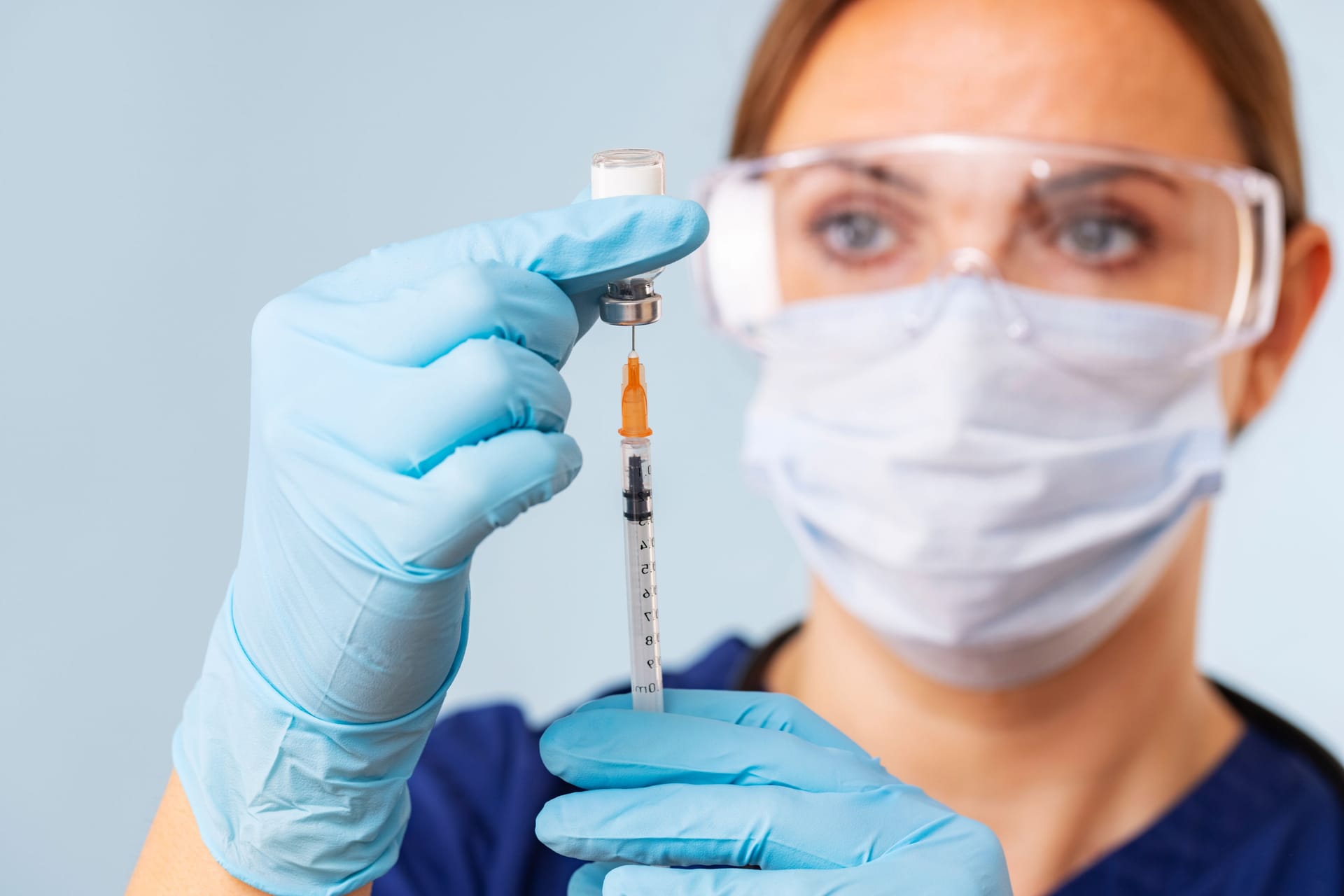 Doctor fills syringe with medicine from vial. Vaccination and immunization Doctor fills syringe with medicine from vial. Vaccination and immunization