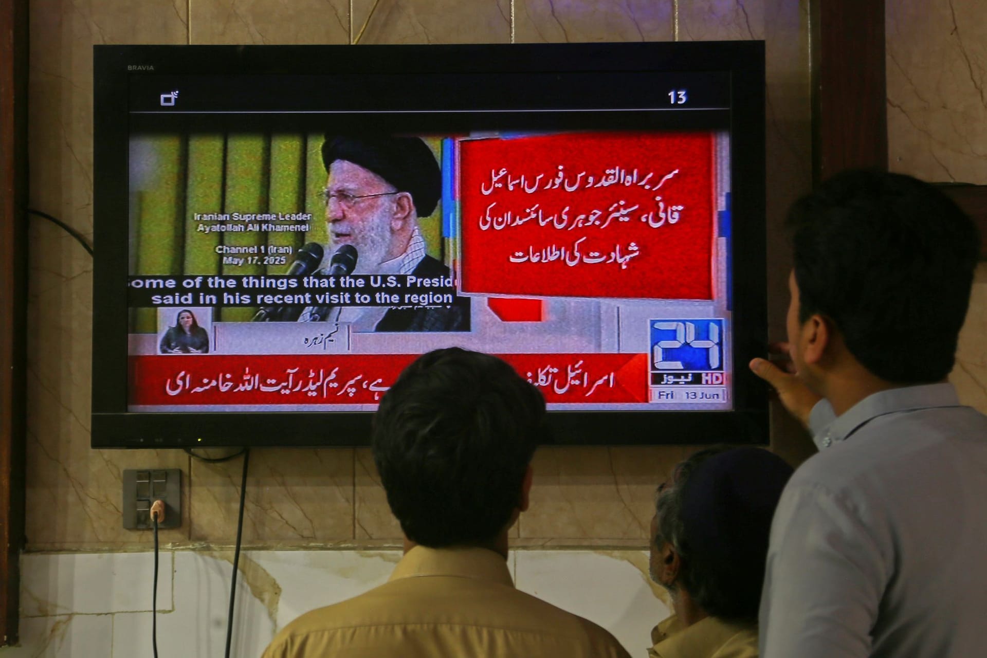 Menschen in Pakistan blicken auf Fernsehbilder: In der Nacht startete Israel Angriffe auf den Iran.